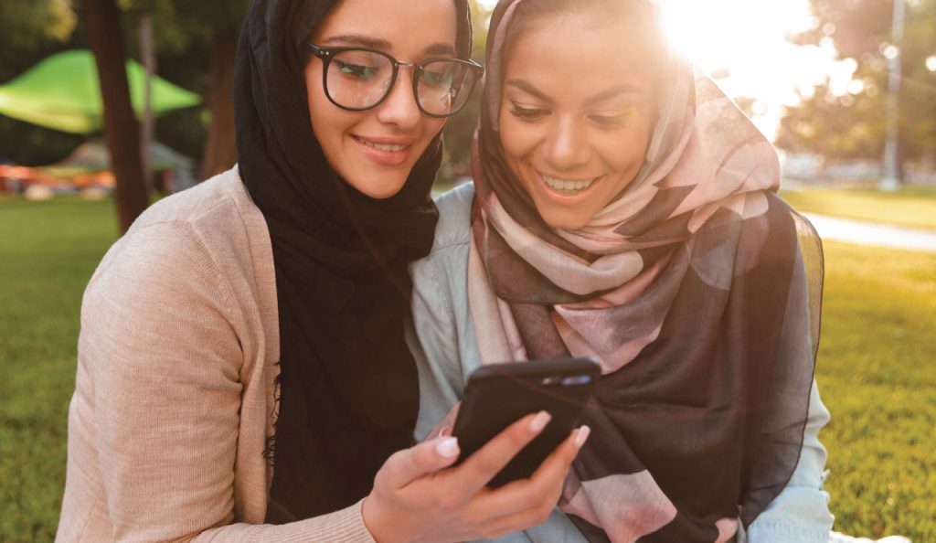 Two friends looking at a mobile together