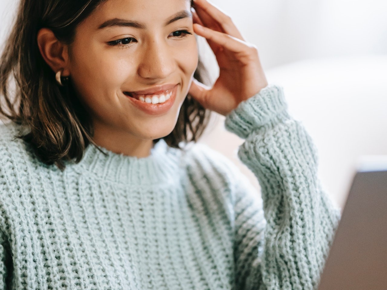 Woman smiling and looking at laptop screen