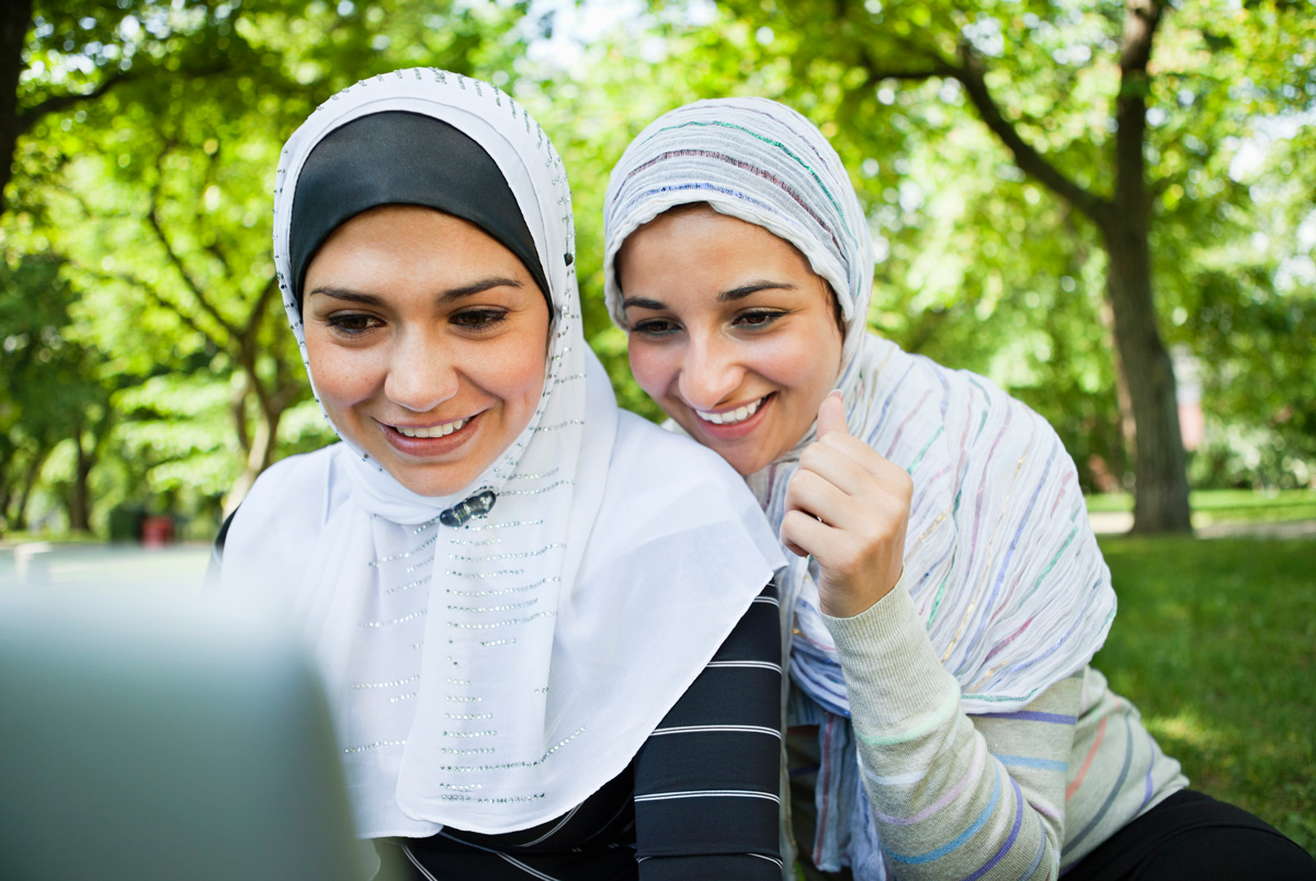 Two female friends using a laptop together