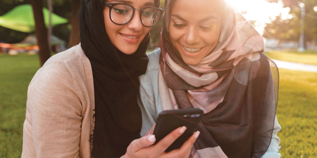 Two friends looking at a mobile together