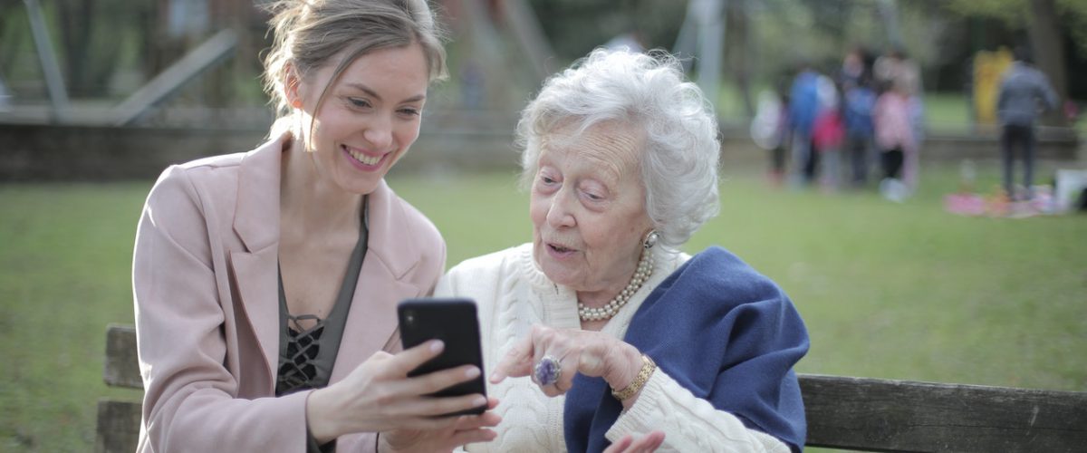 young woman showing older lady how to use a smartphone